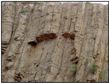 This is a series of 3 pictures that show a feature called columnar jointing.This is a close-up.